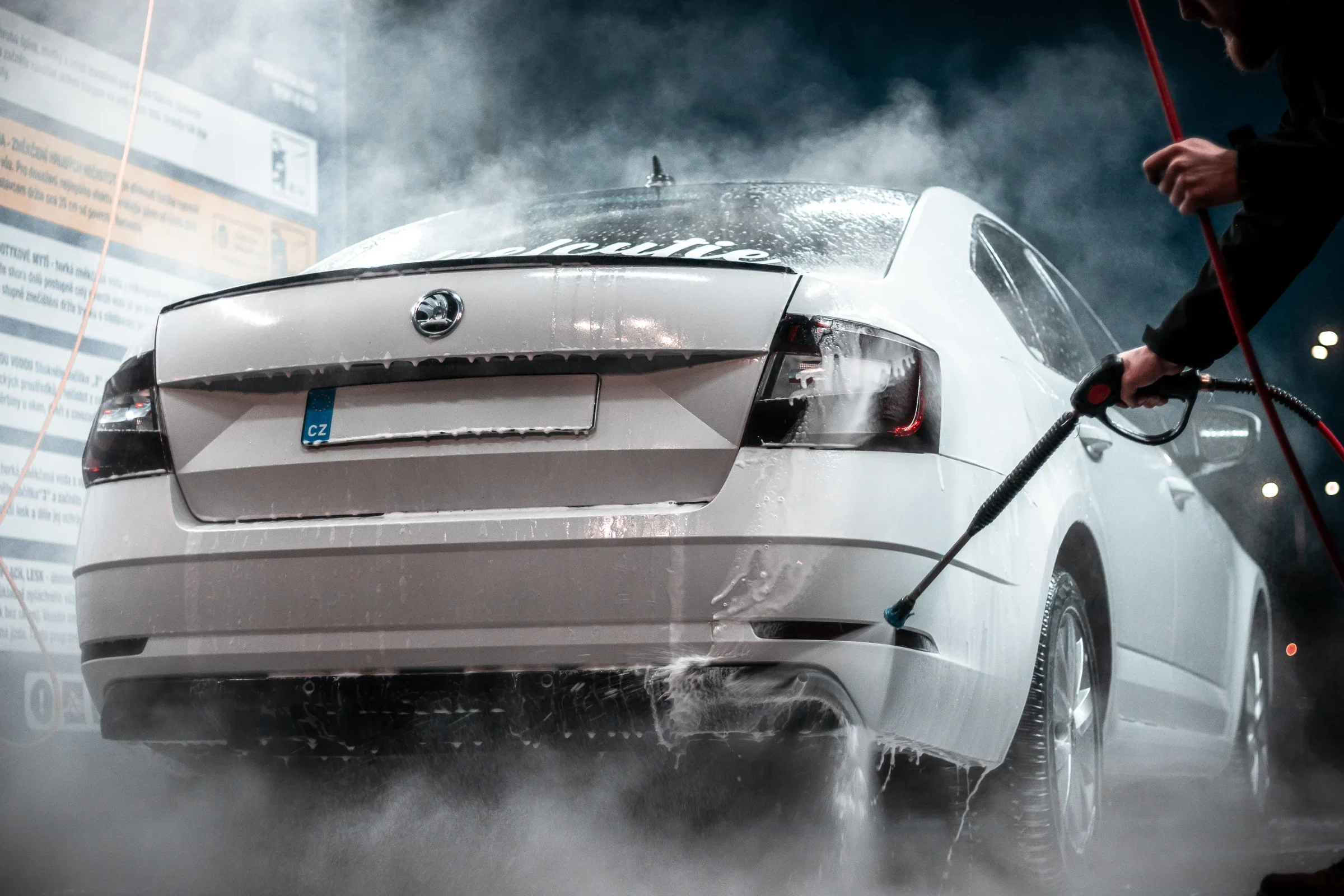 Stříbrná Škoda Octavia v pěně v noci u nápisu Car Wash Center